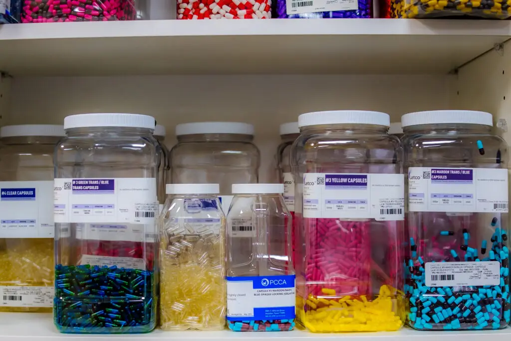 empty capsules in bins ready to be used for compounding medications
