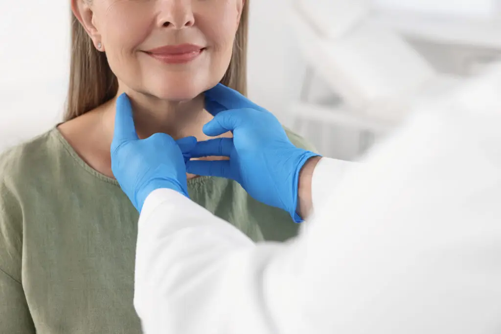 Endocrinologist examining thyroid gland of patient