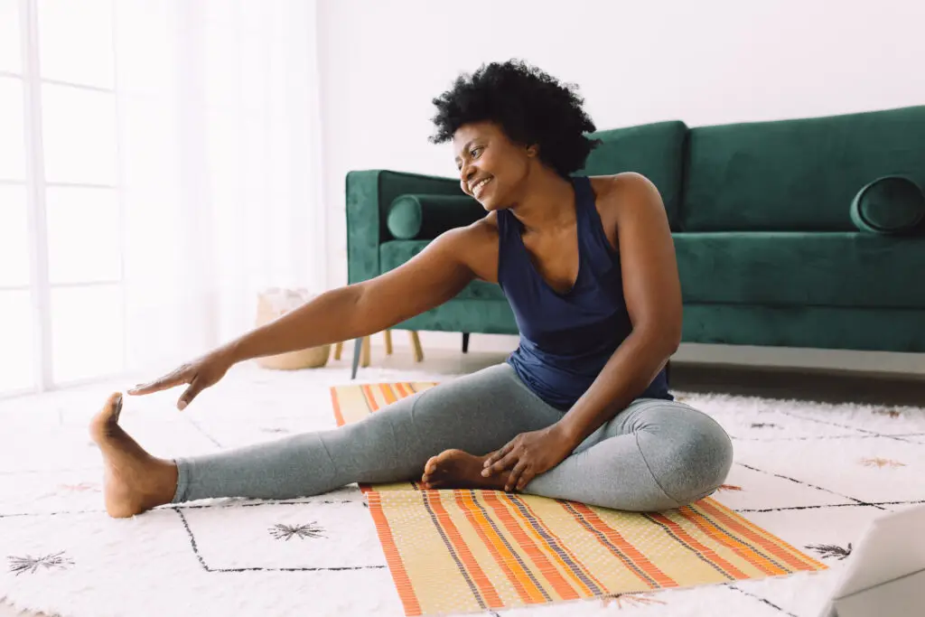 African woman doing yoga on a mat