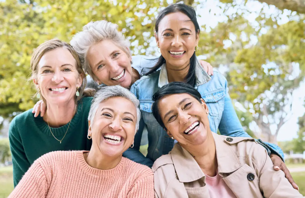 group of women smiling outside the park for a photo